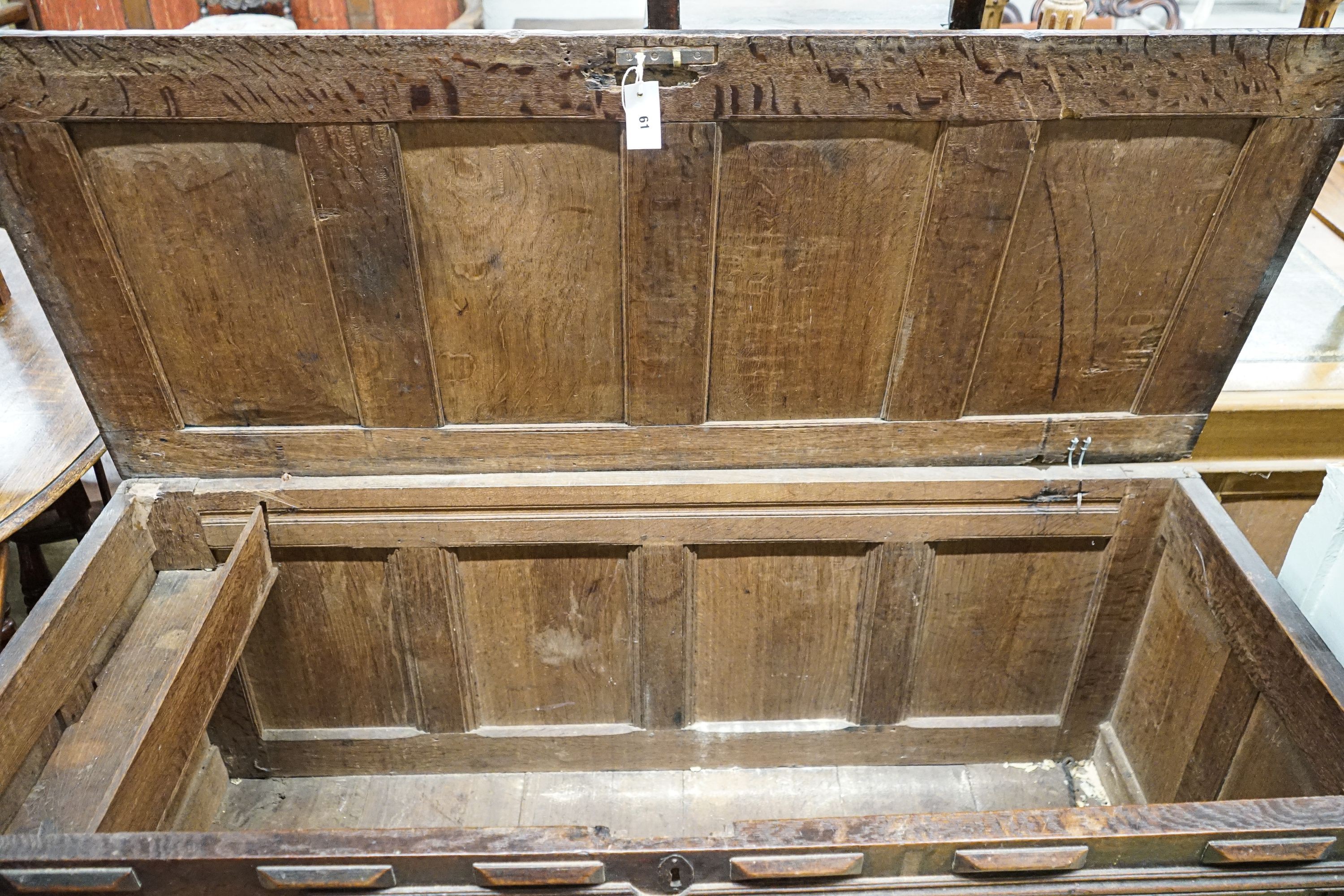 An early 18th century oak coffer, with four panel top and later carved and applied decoration, width 152cm, depth 63cm, height 74cm